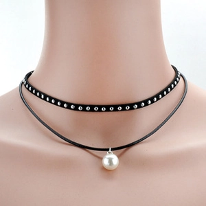 Detail of double-layer choker with silver studs on black band and white pearl pendant