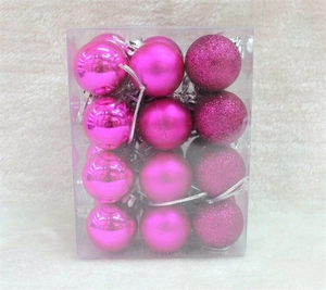 Detail of 12 rose red Christmas balls in shiny, matte, and glitter finishes in a box