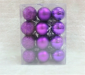 Detail of 24 purple Christmas ornaments in matte and glitter finishes in a clear box
