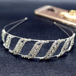 Detail of silver wavy headband featuring sparkling rhinestones on a textured surface