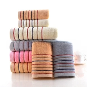 Close-up of stacked soft coral fleece towels with colorful stripes and plush texture