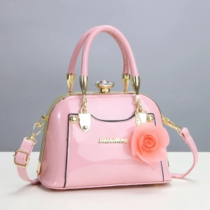 Modische Handtasche aus rosa Lackleder mit Stoffrose und verstellbarem Schultergurt