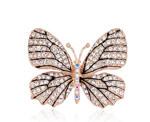 Detailed close-up of a butterfly brooch with crystal pavé and rose gold finish