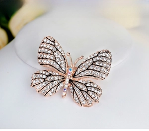 Macro detail of butterfly brooch featuring rose gold plating and crystal inlay