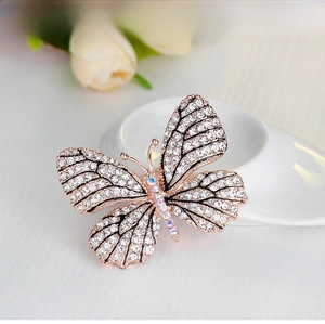 Macro detail of rose gold butterfly brooch with shimmering rhinestones and crystals