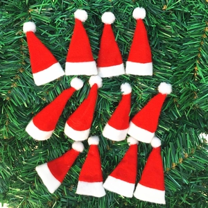 Mini bonnets de Noël rouges et blancs sur fond d'aiguilles de pin pour décoration