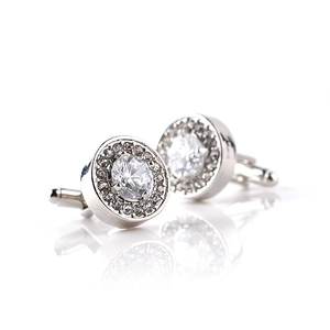 Dettaglio macro di gemelli in lega d'argento con cristallo sfaccettato e strass pavé