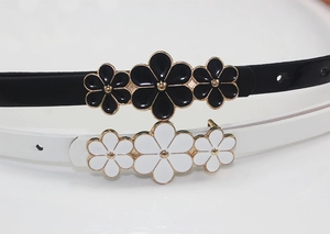 Close-up of thin PU leather belts featuring floral gold buckles with enamel details