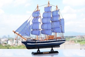 Détail d'un voilier méditerranéen en bois avec voiles à rayures bleues et blanches
