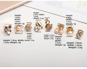 Set of 9 gold alloy brooches featuring owl and swan designs with pearl accents