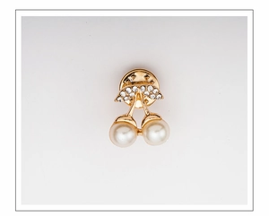 Detailed view of cherry brooch with gold finish, white pearls and sparkling rhinestones