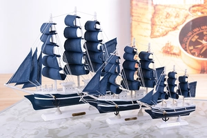Three blue Mediterranean wooden sailboat models in different sizes with metal nameplates