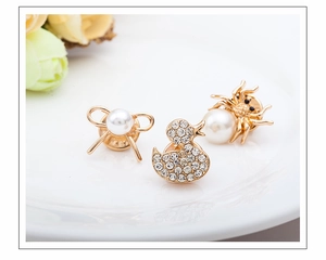 Detail of three-piece jewelry set with gold bow, duck, and spider pins featuring pearls