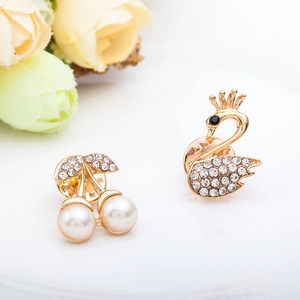 Elegant gold cherry and swan brooches with pearls and rhinestones on a white background