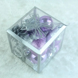 Macro view of purple and silver Christmas ornament set in transparent gift box