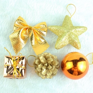 Detailed flat lay of festive gold bow, star, and pine cone Christmas tree ornaments