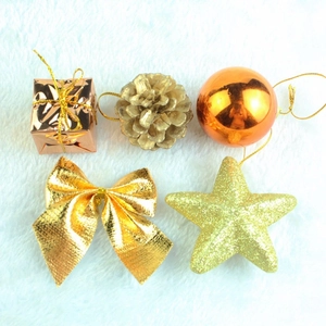 Christmas tree decoration set in warm gold with pine cones and baubles on white fur