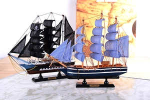 Detail of wooden Mediterranean sailing ship models with blue stripes and pirate sails
