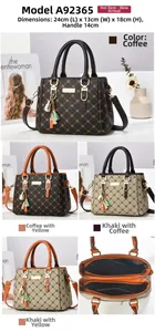 Detail view of the vintage monogram pattern and golden pendant on women's shoulder bag