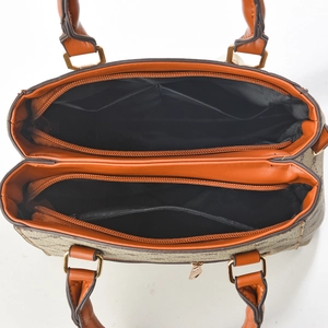 Top-view close-up of brown monogram handbag interior with dual zippers and compartments