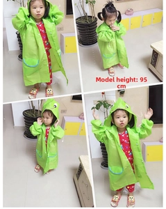 Detailed view of green cartoon animal raincoat with hood and pockets for kids size 95cm