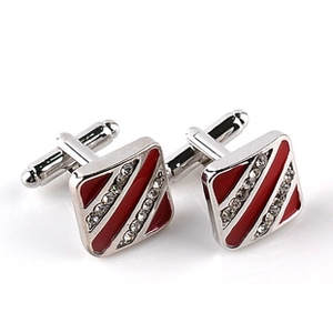 Detail of silver square cufflinks featuring red enamel stripes and sparkling crystal inlay