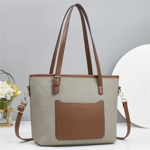 Detail of canvas bucket bag with brown leather trim and fashion lettering