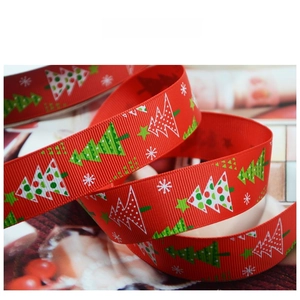 Detail of red grosgrain ribbon featuring festive Christmas tree and snowflake patterns