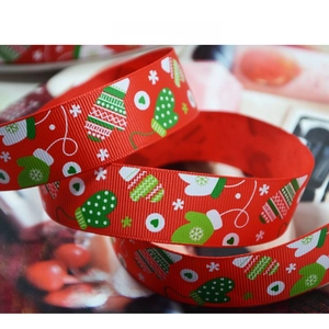 Macro detail of red Christmas grosgrain ribbon with snowflake and glove patterns