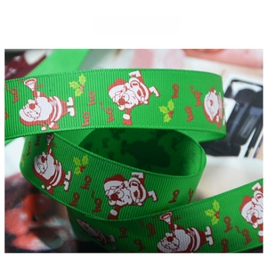 Macro detail of green Christmas grosgrain ribbon with Santa Claus and festive ho ho ho print