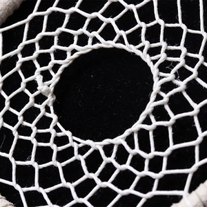 Close-up of the intricate white handmade woven mesh pattern on the peacock dream catcher