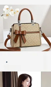 Detail of elegant two-tone handbag featuring a large brown bow and heart-shaped metal handle bases