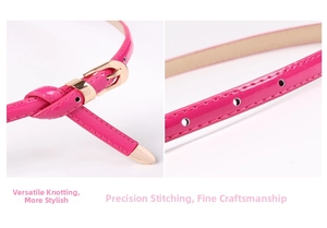 Macro detail of rose red skinny belt with glossy patent finish and fine edge stitching