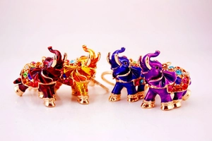 Detailed view of colorful rhinestone elephant keychains in four vibrant enamel finishes