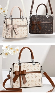 Detailed macro view of monogram bag featuring large decorative bow and heart hardware