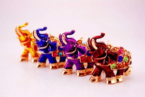 Detailed macro view of four colorful crystal elephant keychains with gold plating