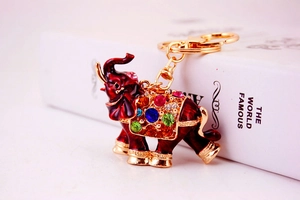 Detail of colorful rhinestones and burgundy enamel on golden elephant keychain