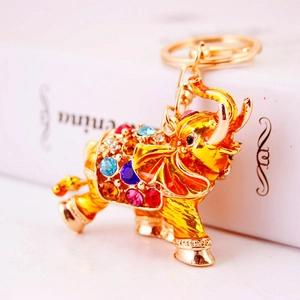 Golden elephant keychain with multi-color rhinestones on a white gift box base