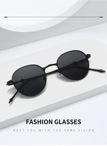 Detail der schmalen schwarzen Metall-Sonnenbrille mit ovalen Gläsern auf weißem Podest