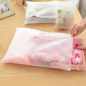Frosted waterproof travel storage bag for clothes and toiletries on a wooden desk