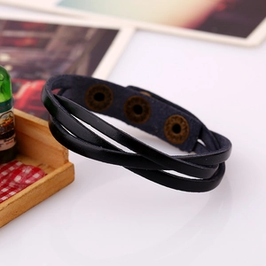 Detail of multi-layer black braided leather bracelet with vintage bronze snap buttons