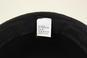 Detail view of the felt hat interior tag showing 50% wool blend and size 57 label
