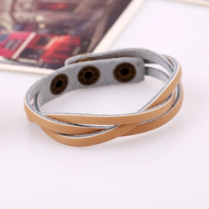 Macro detail of multi-layer light brown braided leather bracelet with vintage metal clasp