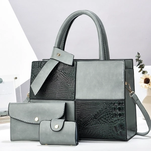 Detail view of crocodile pattern patchwork tote bag set with gold chain and hardware