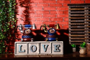 Dettaglio degli orologi da tavolo vintage a forma di telefono in rosso e blu su scatola in legno