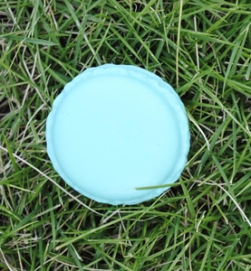 Macro detail of a light blue macaron-shaped jewelry storage box on green grass