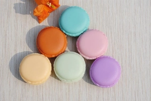 Detailed top view of six colorful macaron jewelry storage boxes on a wooden surface