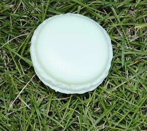 Mini macaron jewelry box in light green placed on green grass for outdoor storage