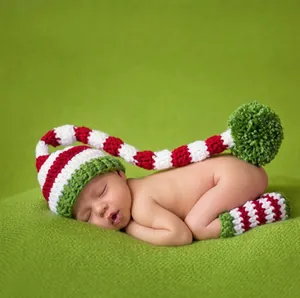 Macro detail of handmade crochet baby Christmas hat and matching striped leg warmers