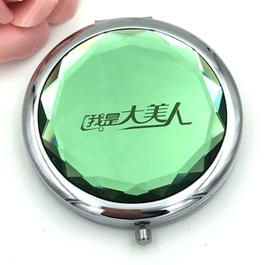 Portable silver metal folding makeup mirror with large green gemstone and floral decor